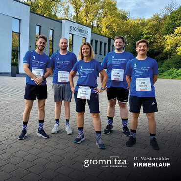 firmenlauf_2023 Fünf Mitarbeiter*innen von ikt Gromnitza vor dem Gebäude der ikt Gromnitza mit Laufshirts.